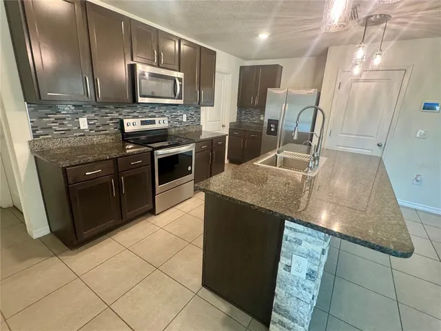 a kitchen with granite countertop a stove and cabinets