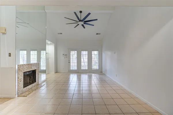 a view of an empty room with a fireplace and a window