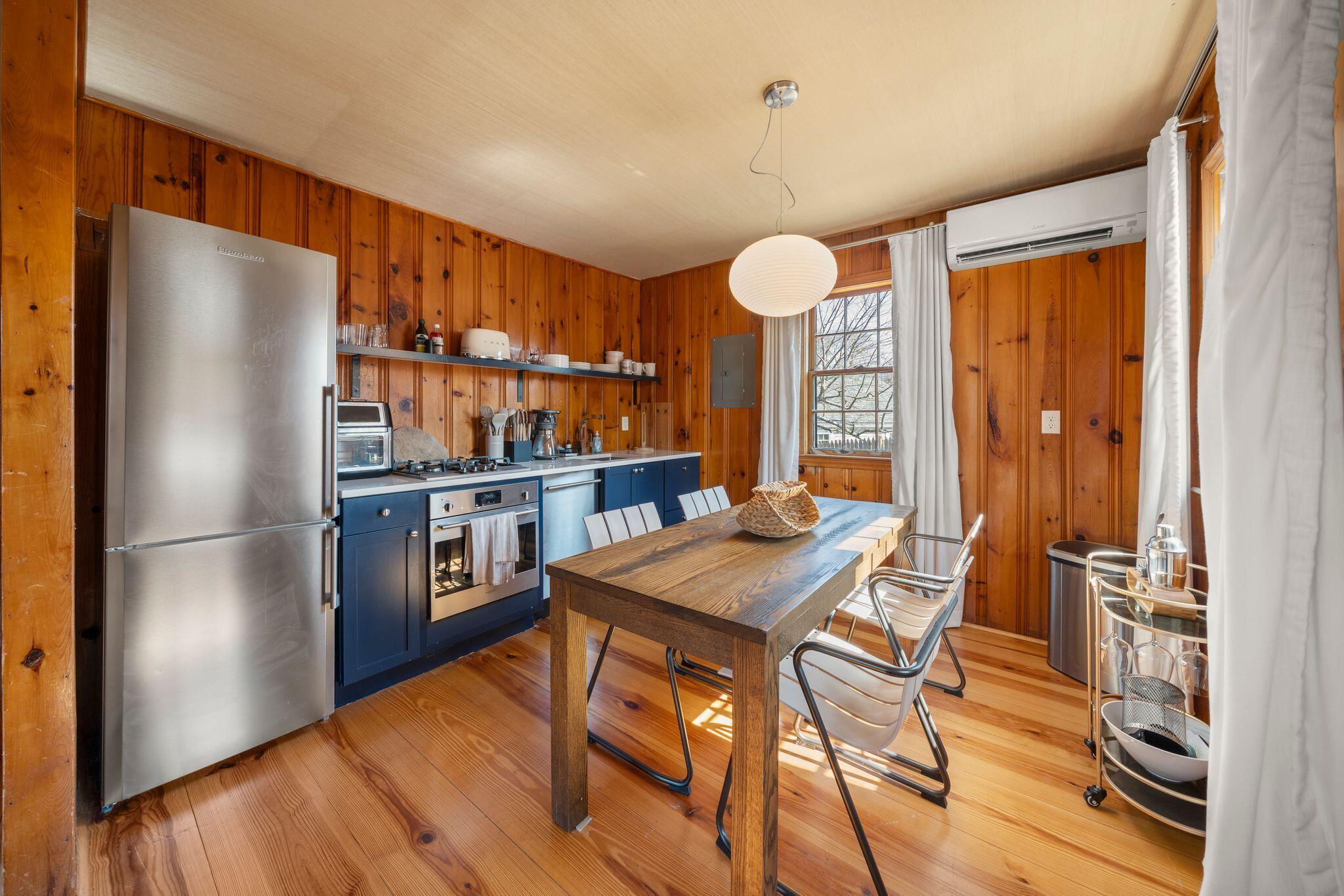 18 Manning Road Dennis Port, MA 02639 - Photo 9 of 34 a kitchen with stainless steel appliances granite countertop a refrigerator a oven a sink and a dining table with wooden floor