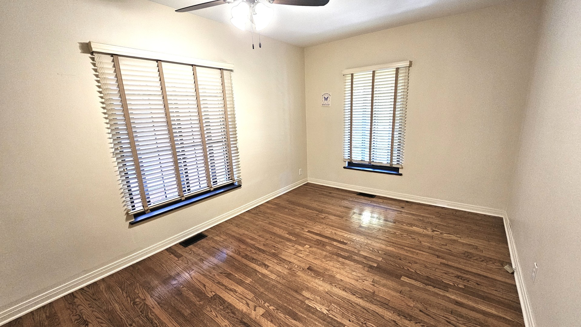 410 North Raynor Avenue, Unit 1W Joliet, IL 60435 - Photo 16 of 64 an empty room with wooden floor and windows