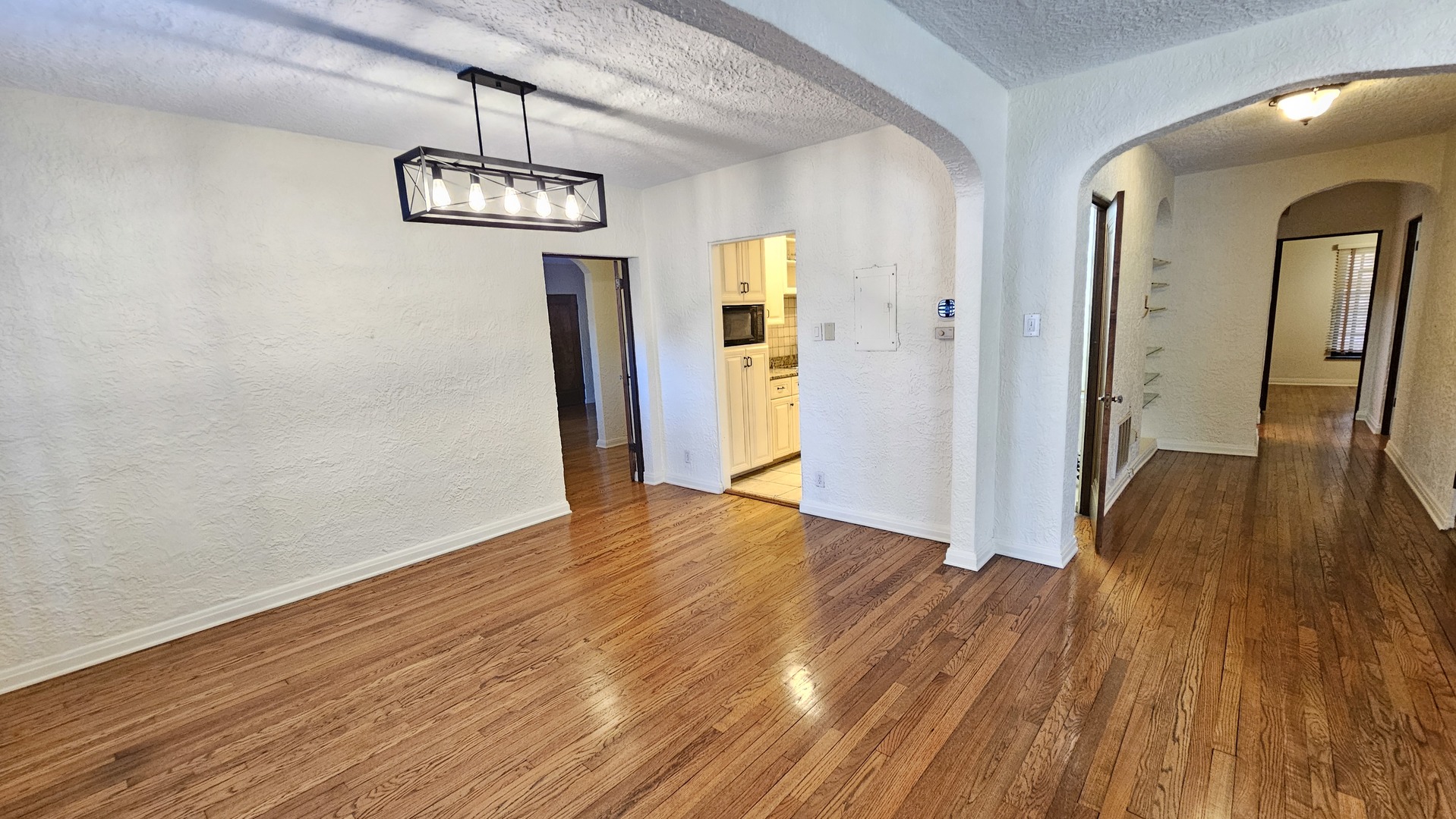 410 North Raynor Avenue, Unit 1W Joliet, IL 60435 - Photo 46 of 64 a view of a room with wooden floor and chandelier