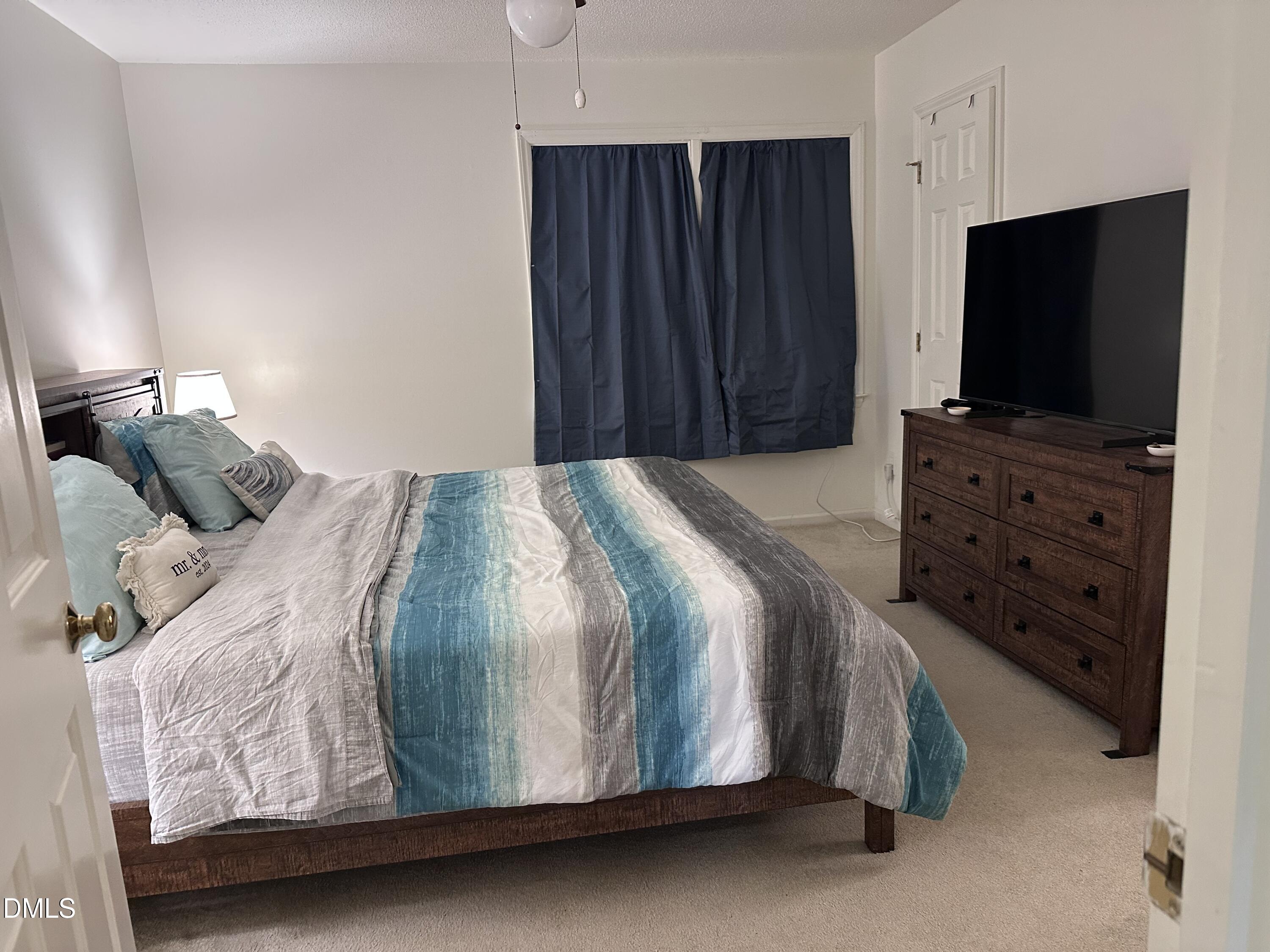 1440 Kent Road Raleigh, NC 27606 - Photo 11 of 21 a bedroom with a bed and a flat tv screen on dresser