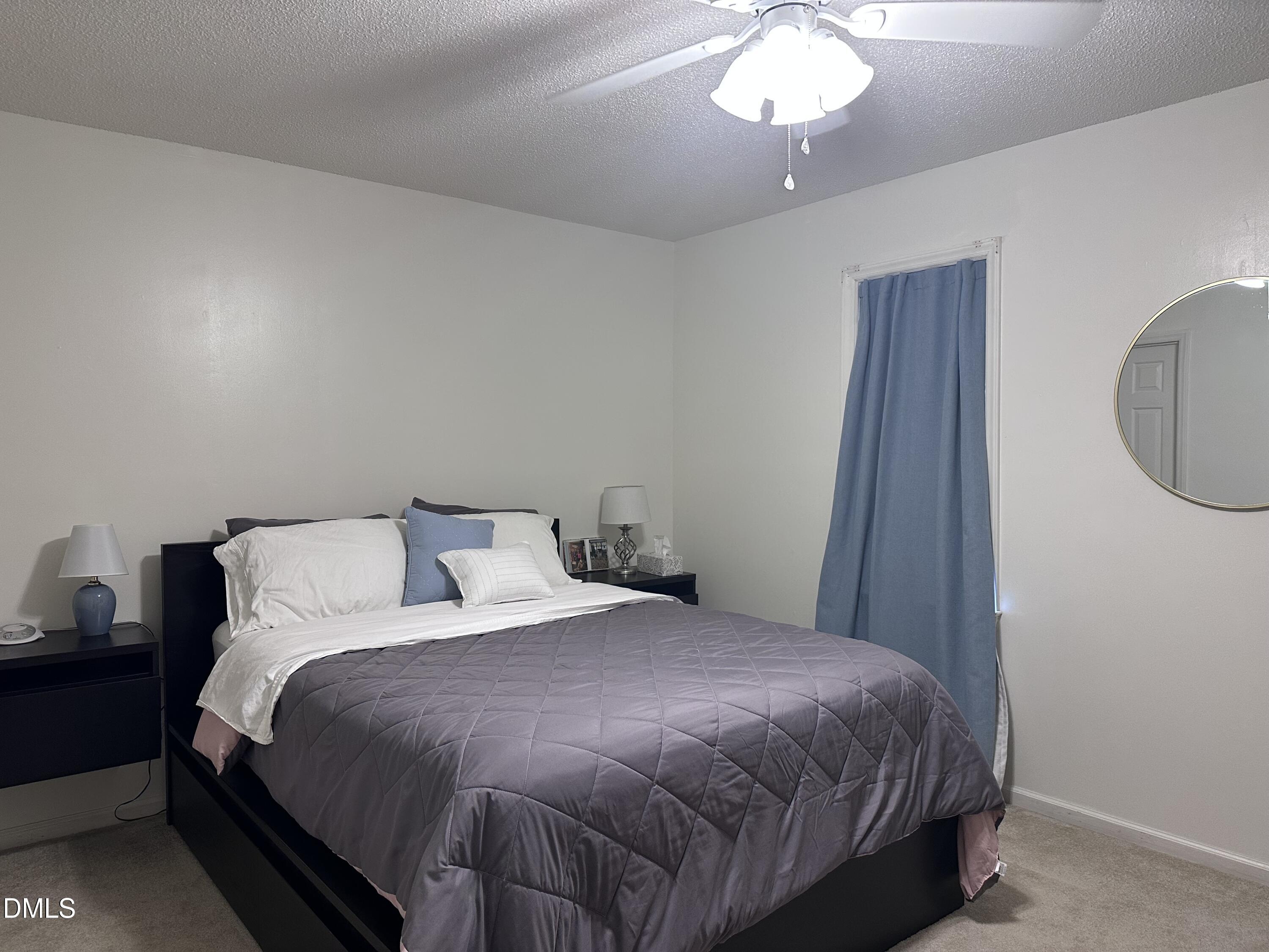 1440 Kent Road Raleigh, NC 27606 - Photo 11 of 13 a bedroom with a bed and a chandelier
