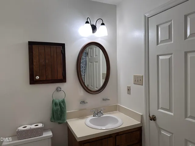 a bathroom with a toilet a sink and mirror