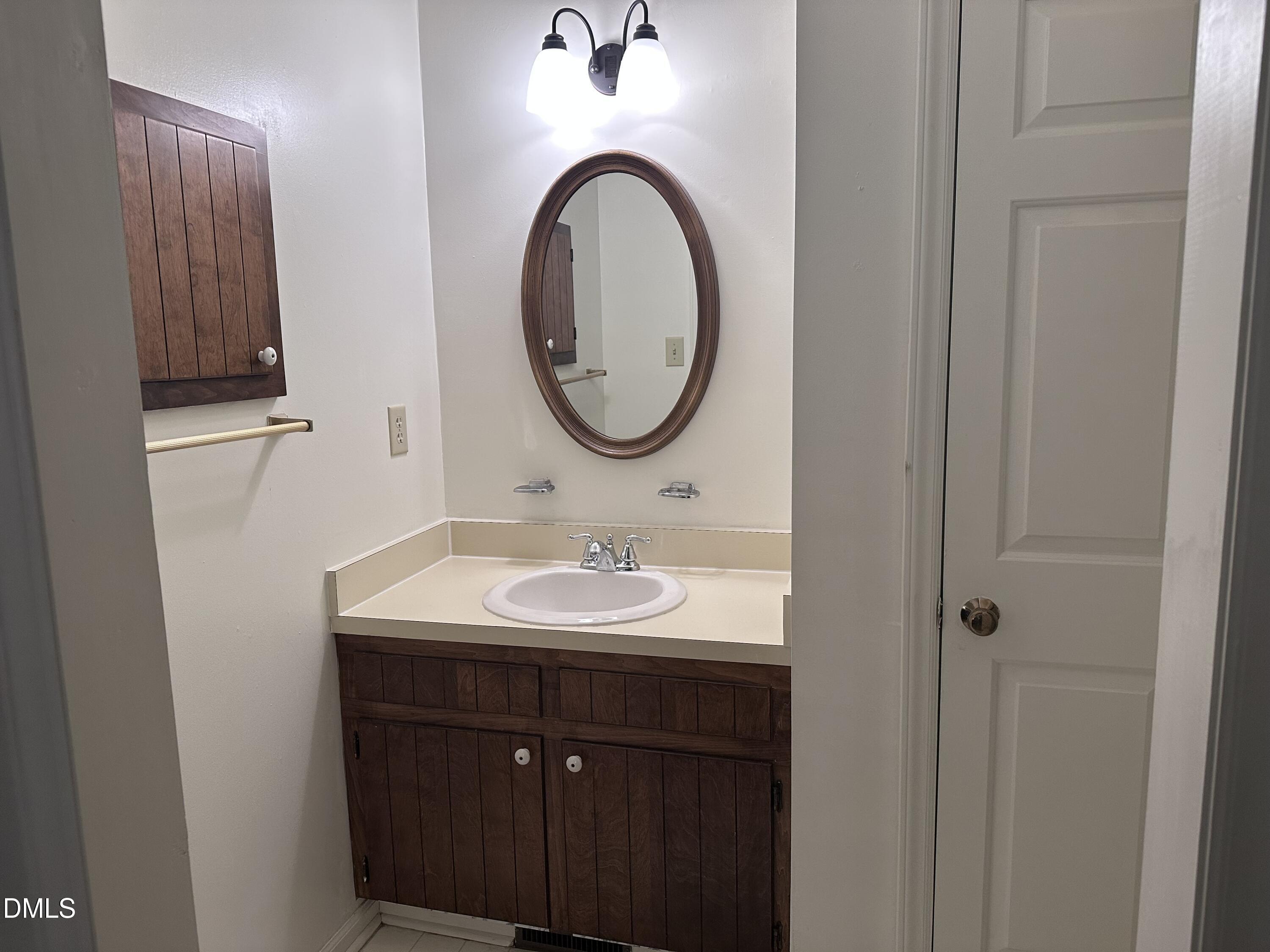 1440 Kent Road Raleigh, NC 27606 - Photo 8 of 13 a bathroom with a sink and a mirror