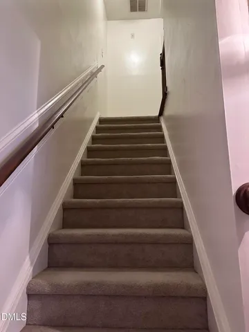 a bedroom with a bed and a flat tv screen on dresser