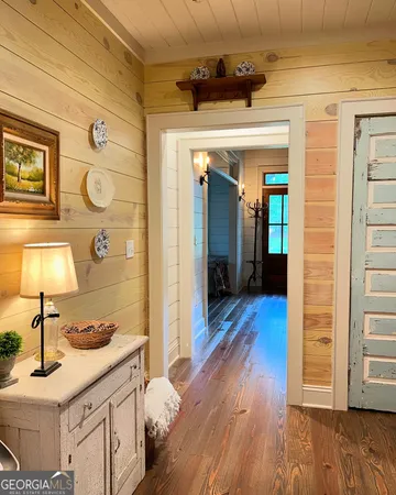 a hallway view with wooden floor and staircase