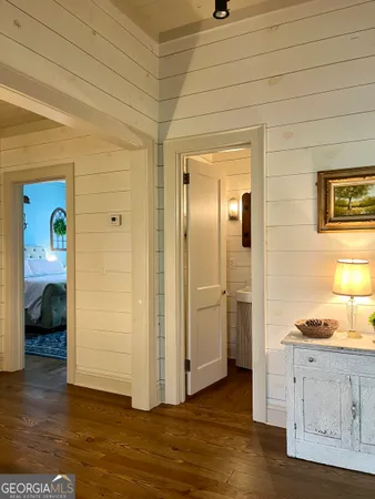 a view of a hallway with wooden floor and closet area