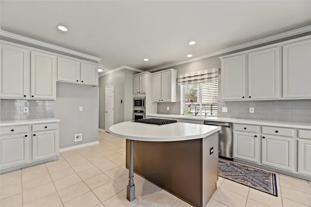 a kitchen with a sink a stove a refrigerator and white cabinets