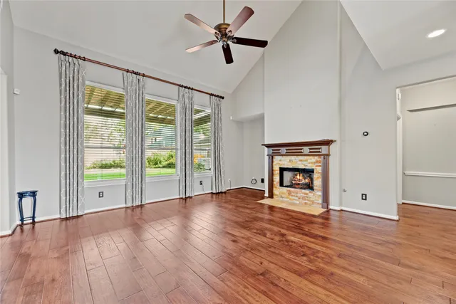 a view of an empty room with window and wooden floor