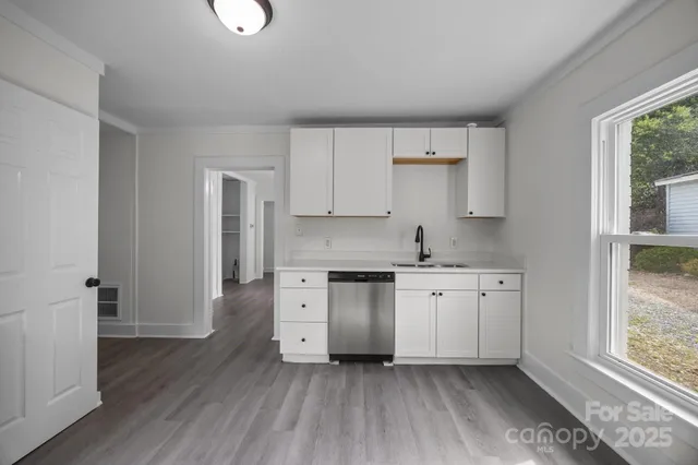 a kitchen with stainless steel appliances granite countertop a stove a sink and a refrigerator with wooden floors