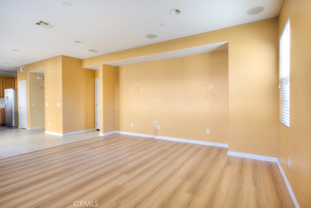 4587 Vincent Way Riverside, CA 92501 - Photo 13 of 51 a view of an empty room with wooden floor and a window