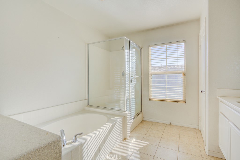 4587 Vincent Way Riverside, CA 92501 - Photo 28 of 51 a bathroom with a tub shower and a sink