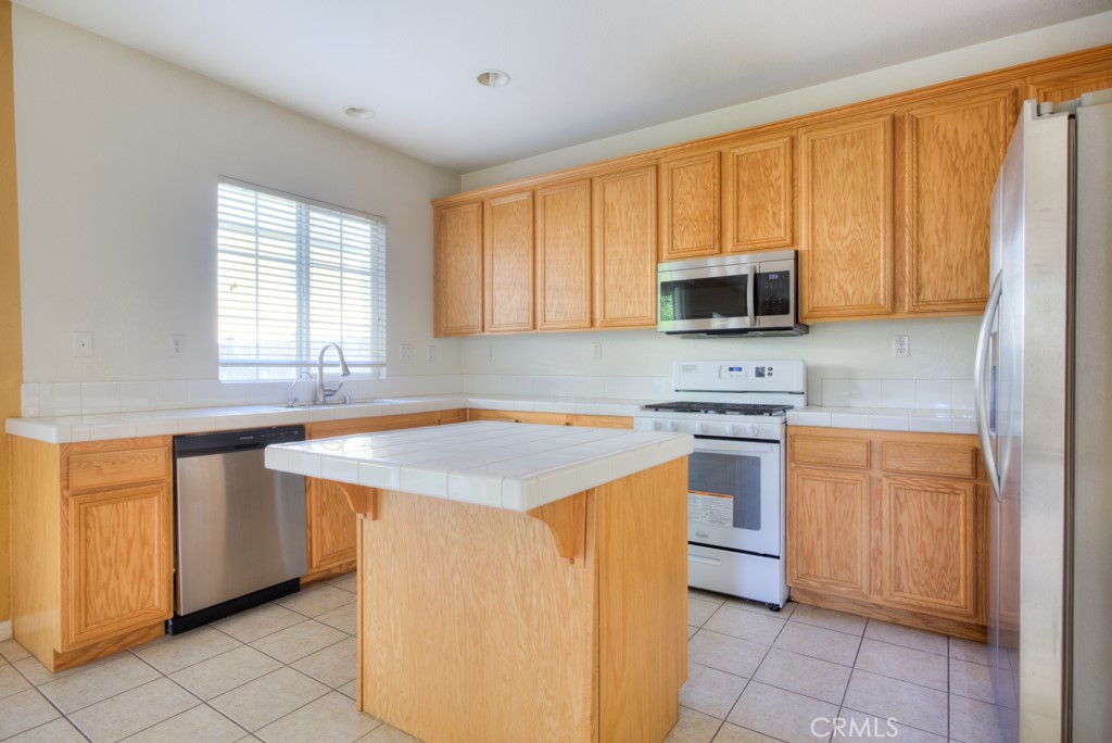 4587 Vincent Way Riverside, CA 92501 - Photo 8 of 51 a kitchen with stainless steel appliances granite countertop a stove a sink and a microwave