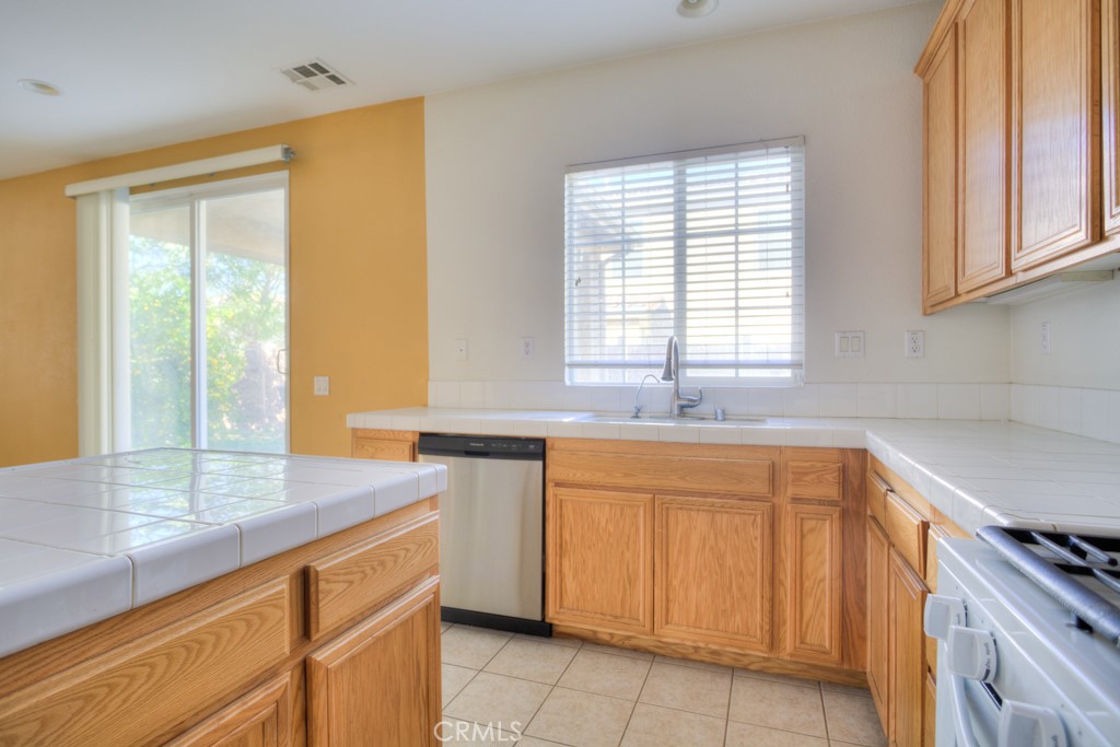 4587 Vincent Way Riverside, CA 92501 - Photo 9 of 51 a kitchen with granite countertop a sink and white cabinets
