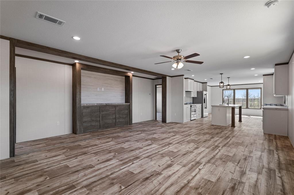 3924 Sandusky Road Whitesboro, TX 76273 - Photo 6 of 22 Unfurnished living room with light wood-type flooring, a ceiling fan, and suspended lighting