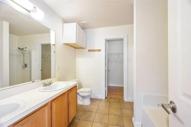 a bathroom with a granite countertop sink a toilet and shower