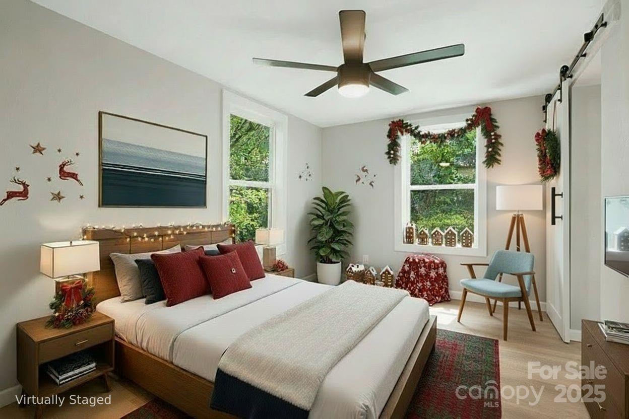 95 Grassy View Road Candler, NC 28715 - Photo 14 of 27 a bedroom with a bed a chandelier and a large window