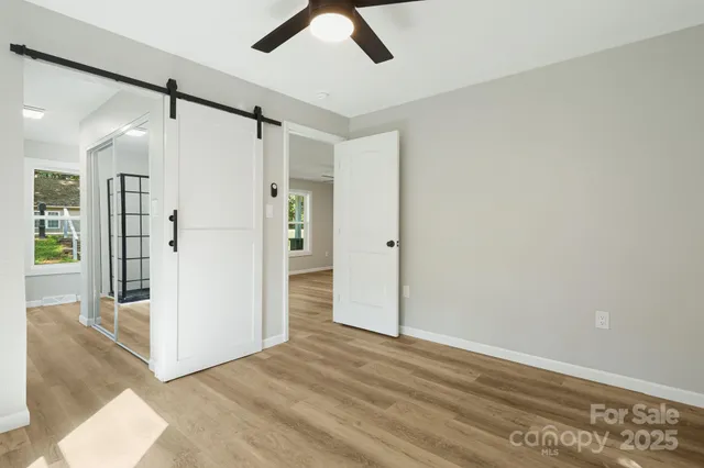 a view of a big room with wooden floor and a ceiling fan