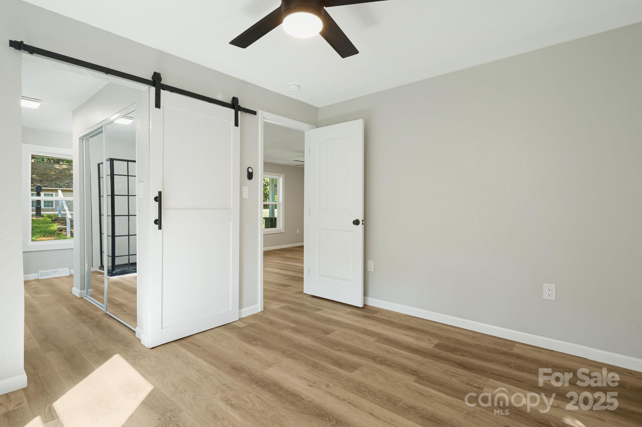 95 Grassy View Road Candler, NC 28715 - Photo 15 of 27 a view of a big room with wooden floor and a ceiling fan