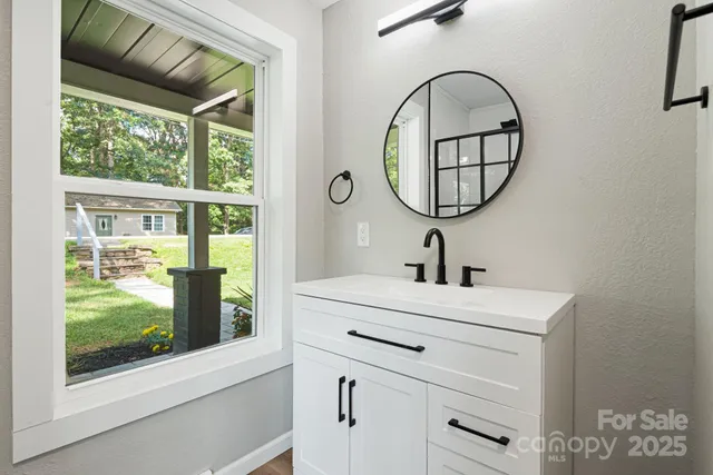 a bathroom with a sink mirror and a window