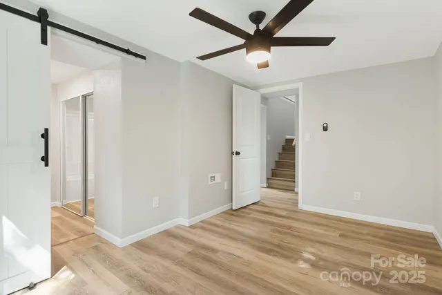 a view of a big room with wooden floor and a ceiling fan