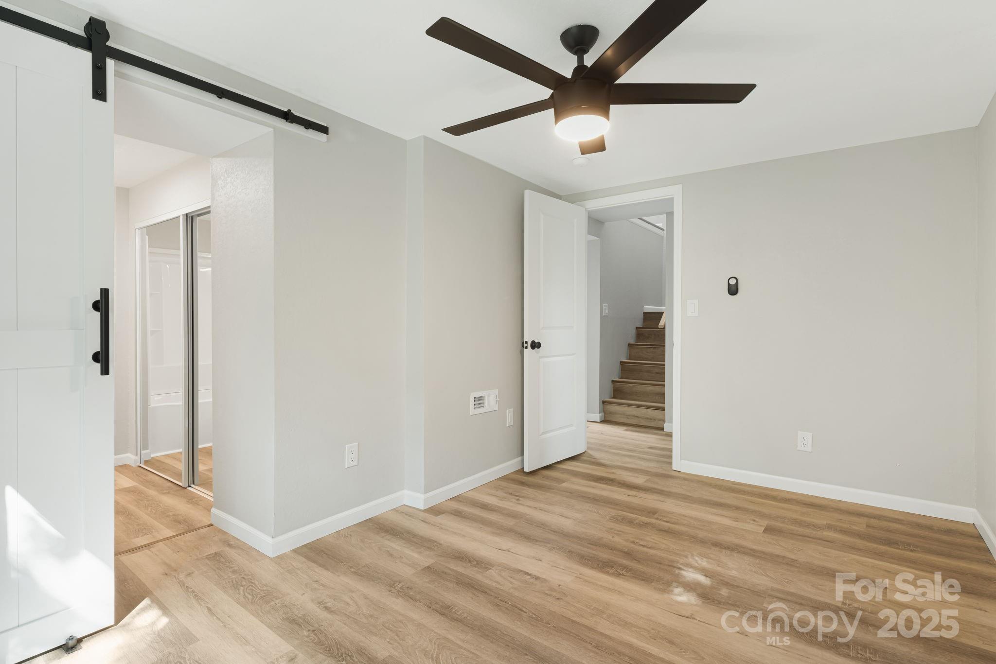 95 Grassy View Road Candler, NC 28715 - Photo 18 of 27 a view of a big room with wooden floor and a ceiling fan