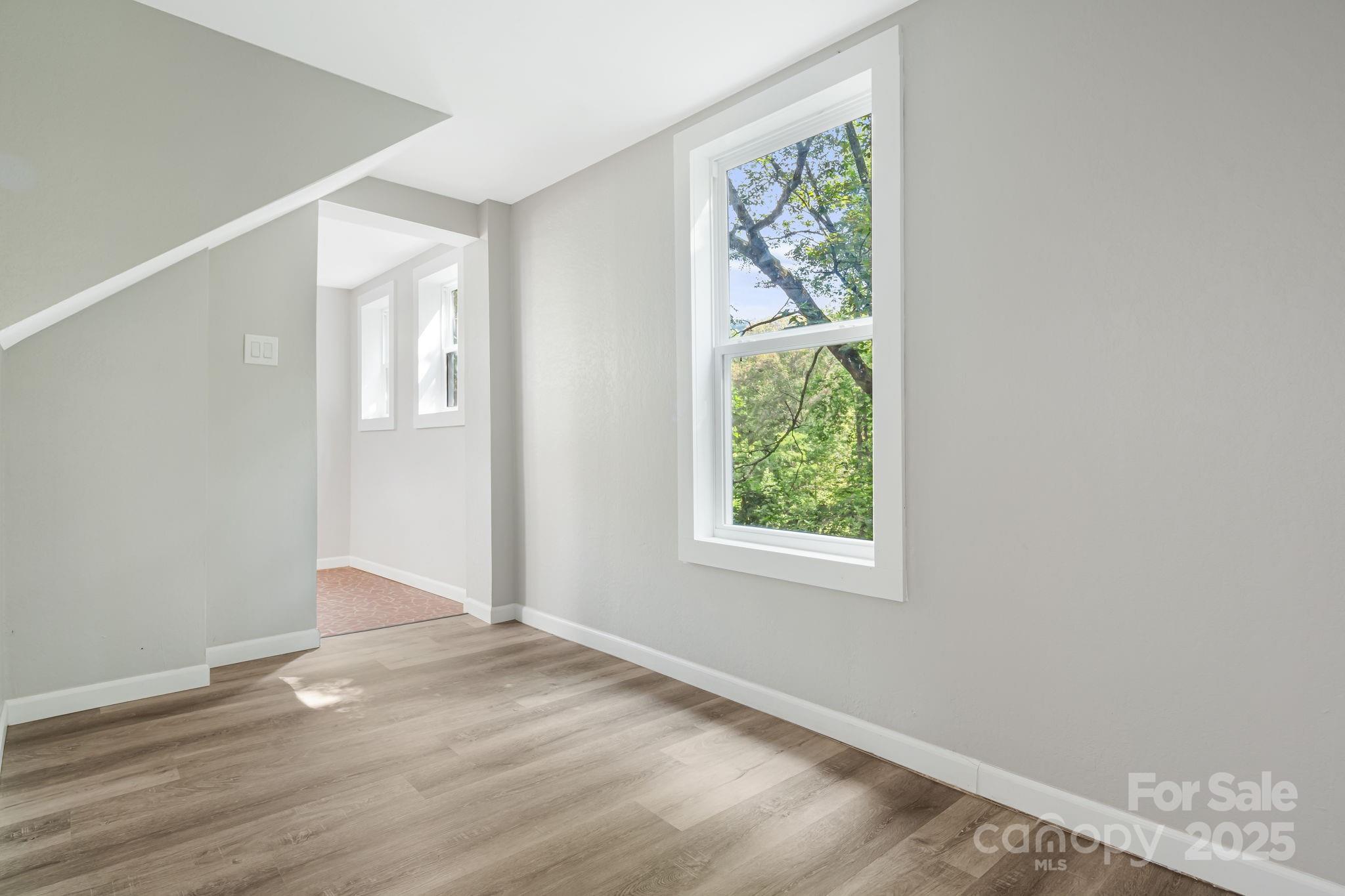 95 Grassy View Road Candler, NC 28715 - Photo 22 of 27 an empty room with wooden floor and windows