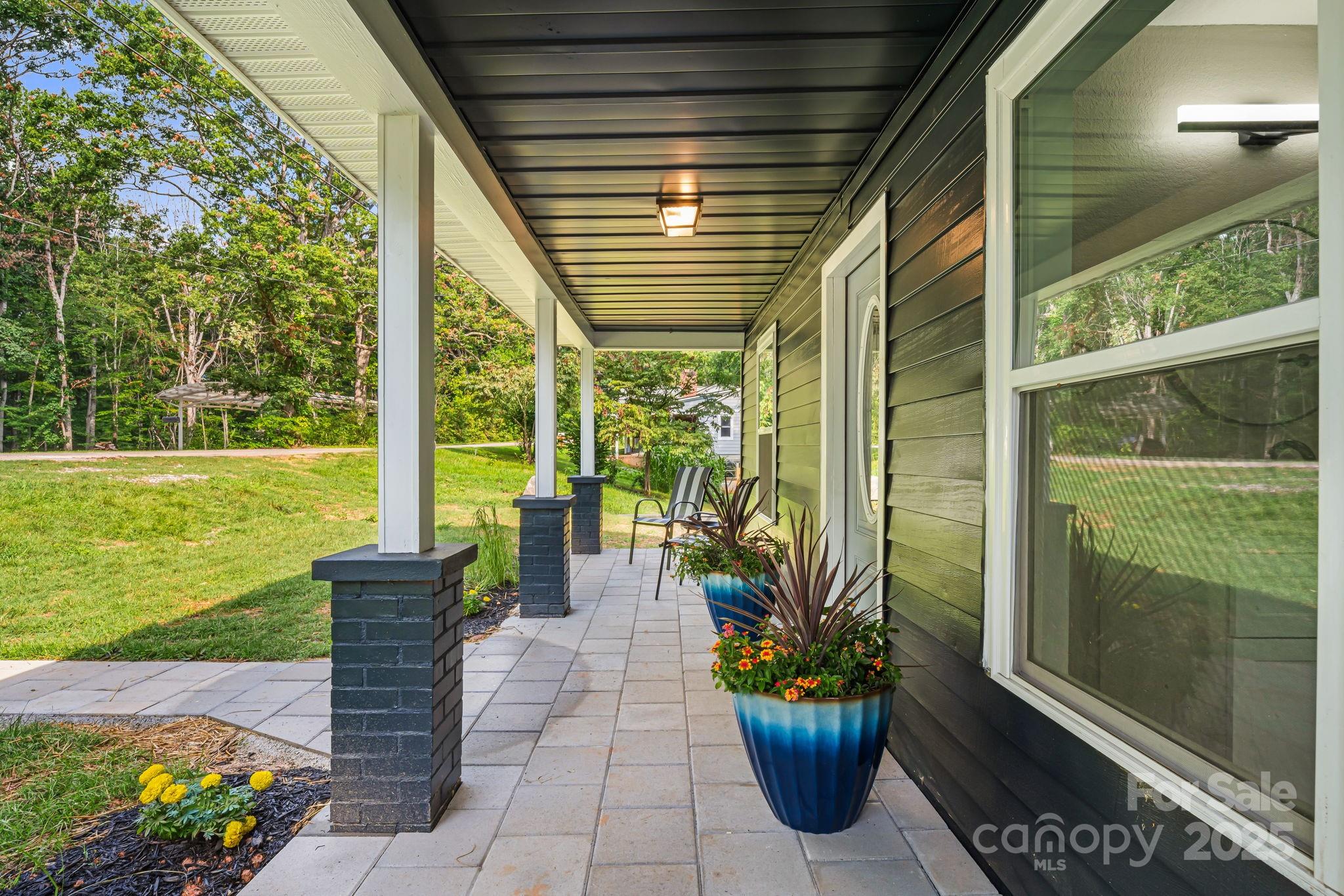 95 Grassy View Road Candler, NC 28715 - Photo 3 of 27 a porch with chairs and potted plants