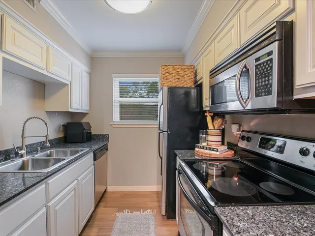 a kitchen with stainless steel appliances granite countertop a sink stove and refrigerator