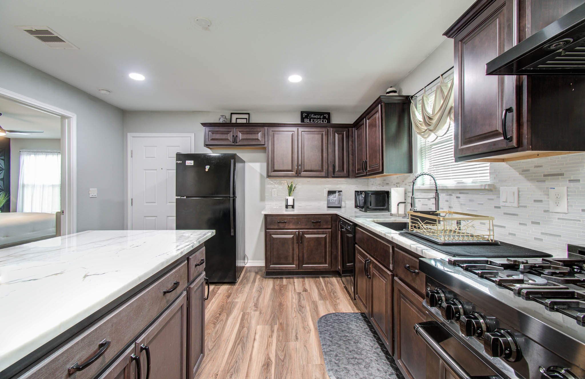 2722 Vega Houston, TX 77088 - Photo 22 of 45 a kitchen with stainless steel appliances granite countertop a stove top oven a sink dishwasher a refrigerator and cabinets with wooden floor