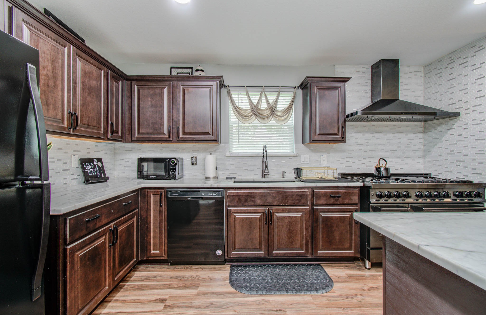 2722 Vega Houston, TX 77088 - Photo 23 of 45 a kitchen with stainless steel appliances granite countertop a stove a sink dishwasher and cabinets with wooden floor