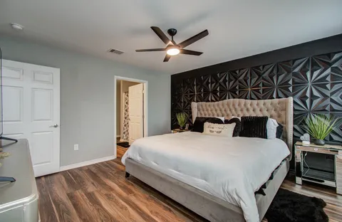 a bedroom with a large bed and a ceiling fan