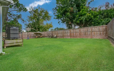 a view of a yard with a wooden fence