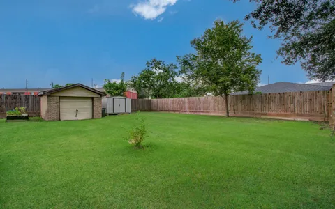 a view of a house next to a yard with large trees