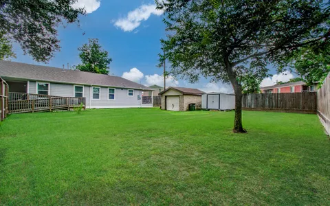 a view of a backyard with a cabin and wooden fence