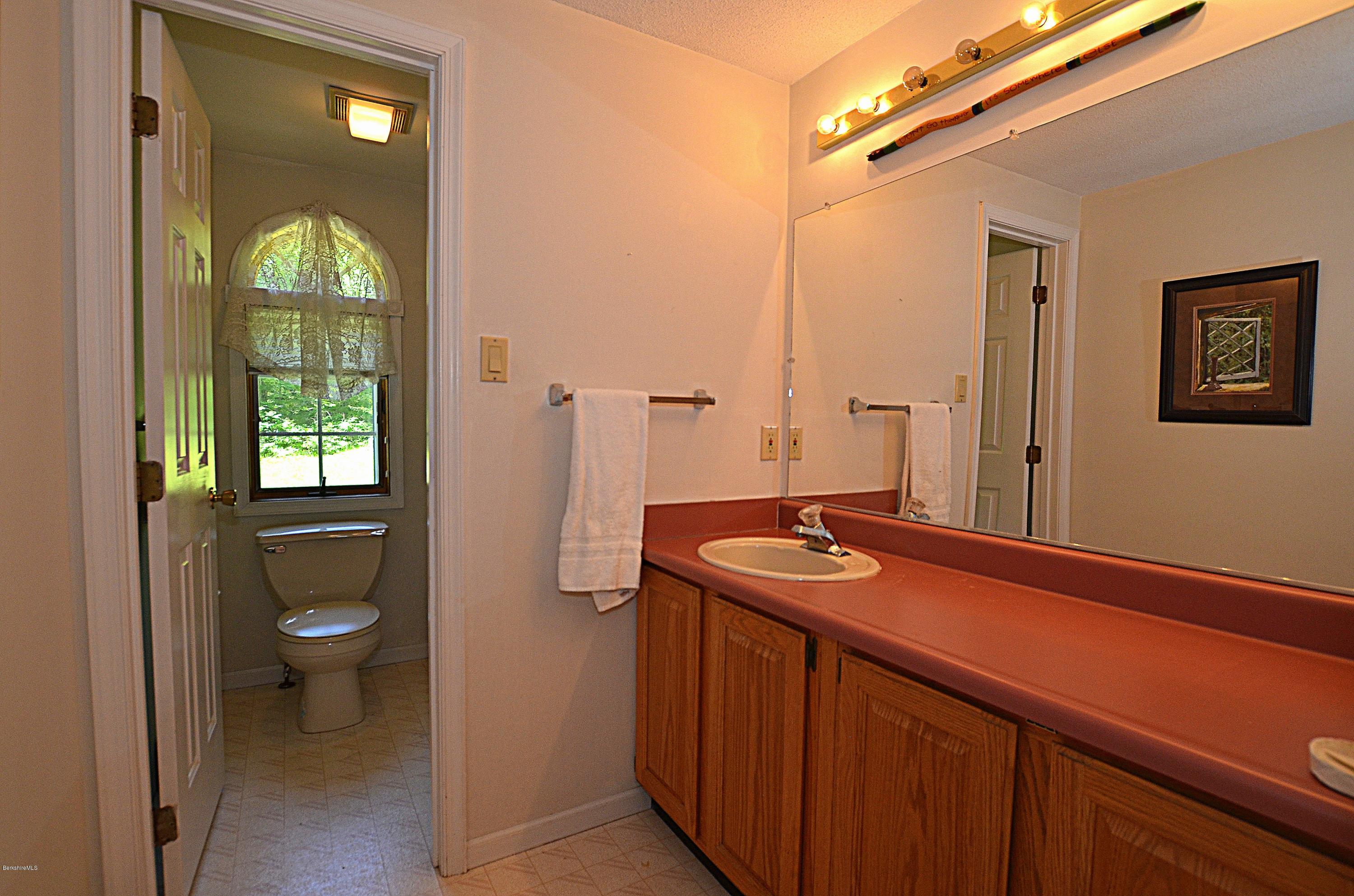 982 Fred Snow Road Becket, MA 01223 - Photo 11 of 21 a bathroom with a granite countertop sink toilet and shower