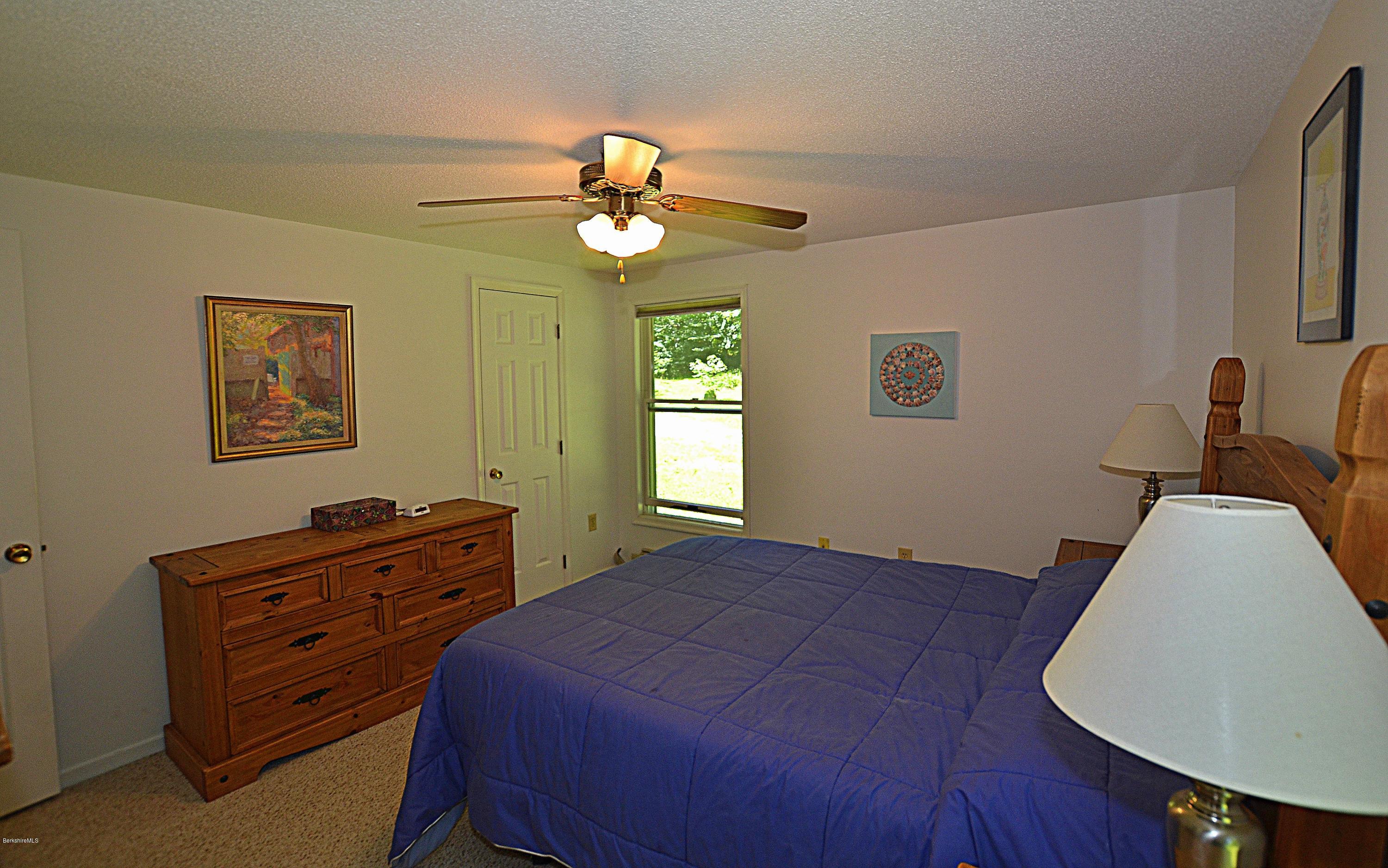 982 Fred Snow Road Becket, MA 01223 - Photo 13 of 21 a bedroom with a bed and a dresser