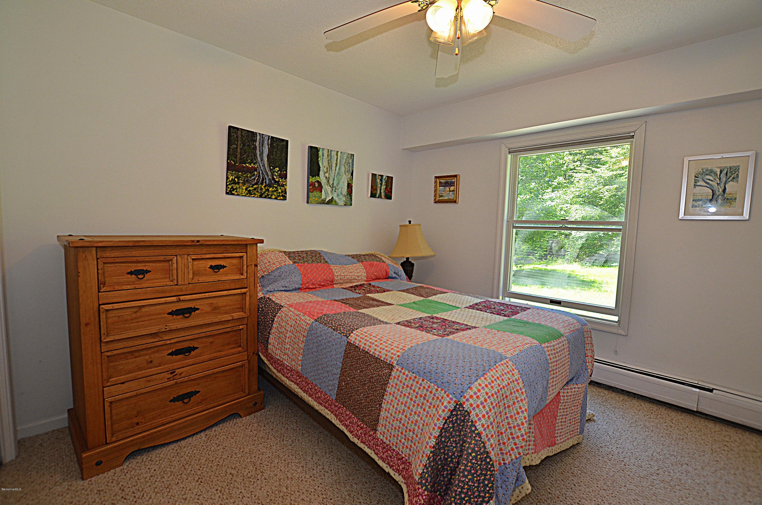 982 Fred Snow Road Becket, MA 01223 - Photo 9 of 21 a bedroom with a bed and a dresser