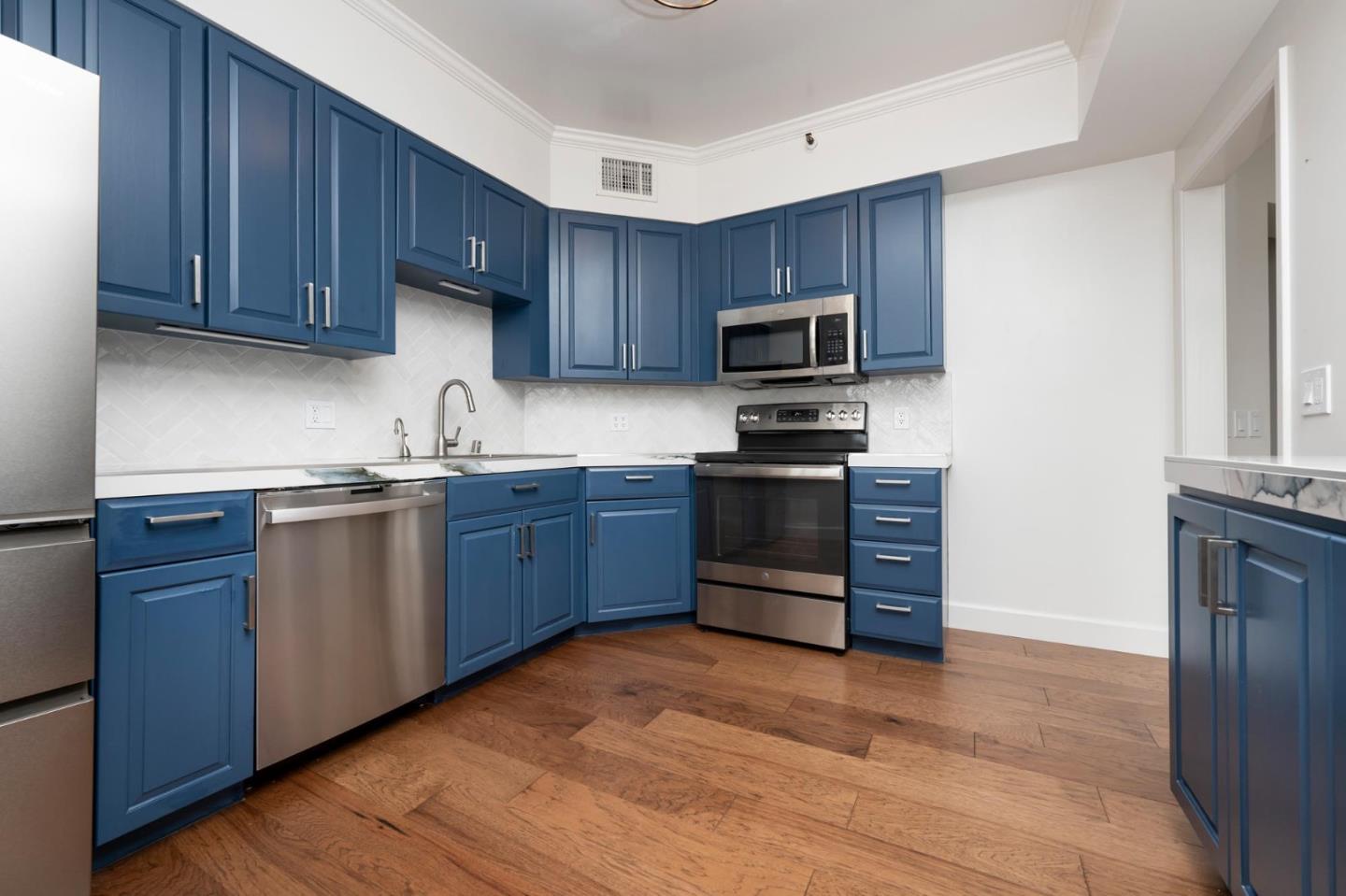 1 Baldwin Avenue, Unit 1017 San Mateo, CA 94401 - Photo 1 of 8 a kitchen with wooden cabinets and stainless steel appliances
