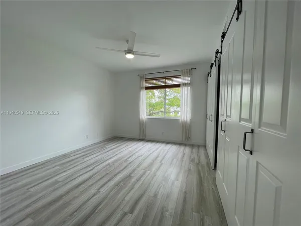 an empty room with wooden floor and a window