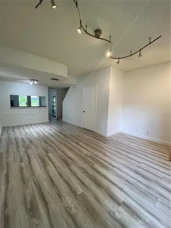 a view of a room with wooden floor and white walls