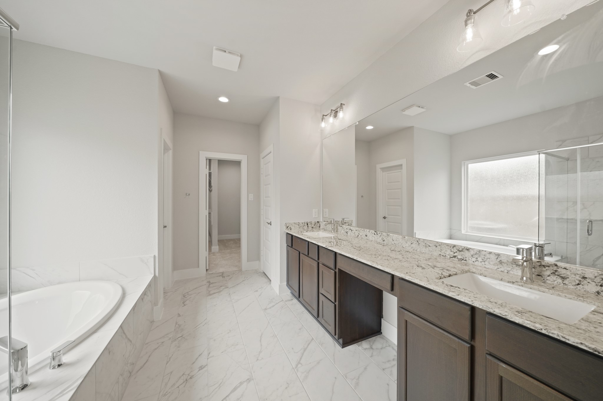 3319 Pin Cherry Lane Conroe, TX 77301 - Photo 15 of 30 a bathroom with a granite countertop double vanity sink a mirror and a bathtub