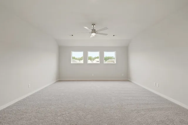 an empty room with a window and a ceiling fan