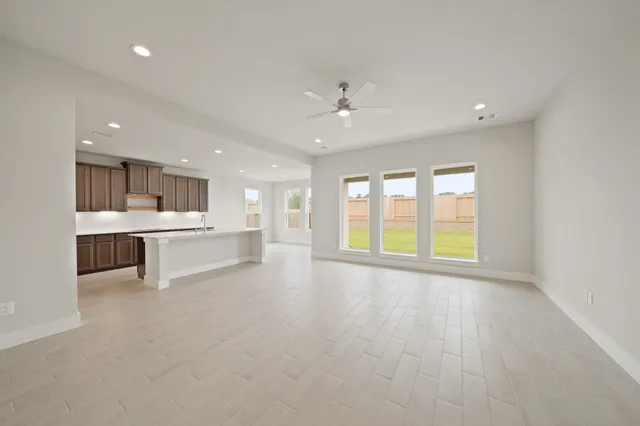 a view of an empty room with a kitchen stove and a window