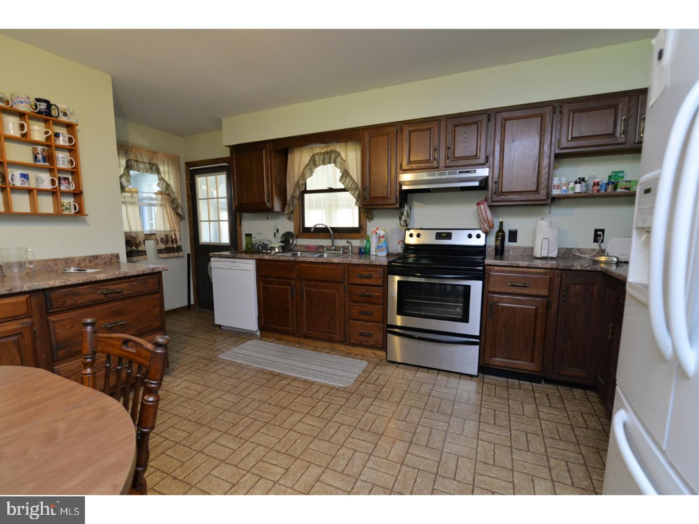 307 Germanville Road Ashland, PA 17921 - Photo 13 of 24 a kitchen with stainless steel appliances granite countertop a stove top oven a sink dishwasher a dining table and chairs with wooden floor