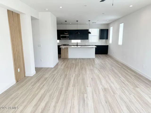 a kitchen with stainless steel appliances granite countertop a sink a stove and a wooden floors