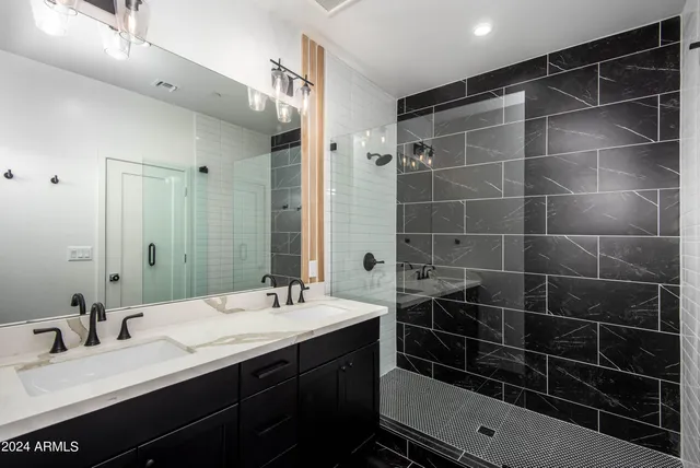 a bathroom with a double vanity sink mirror and shower