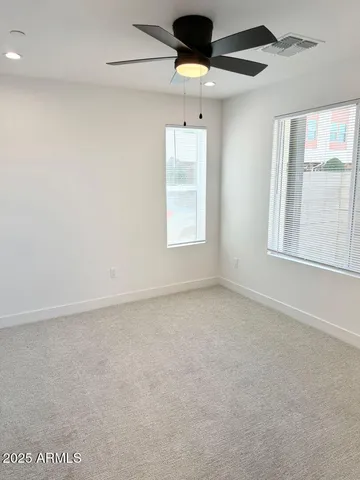 an empty room with closet and windows