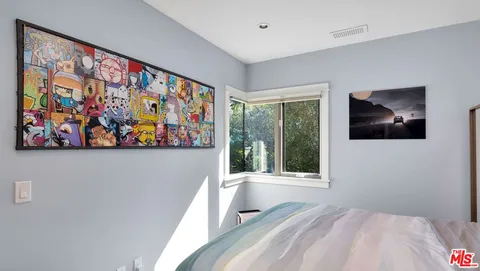 a view of a bedroom with furniture and large window